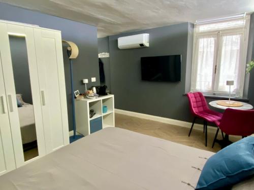 a room with a bed and a table and a tv at Chagall Bijoux in Asti