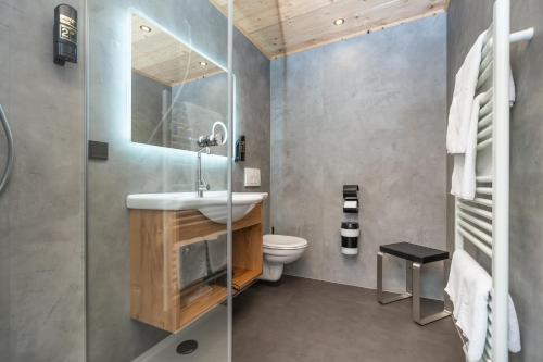 a bathroom with a sink and a toilet at Hotel Sonnenspitz *** in Kochel