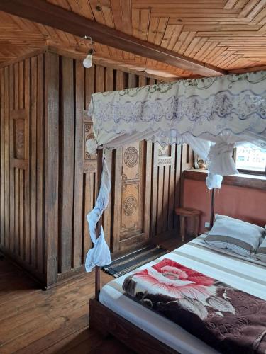a bedroom with a bed with a canopy at Hotel Anjara in Ambositra