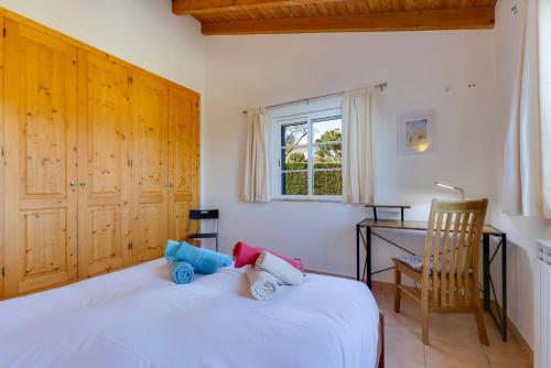 a bedroom with a white bed and a desk at Vila Fantastica in Aljezur