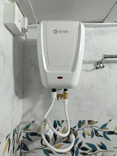 a white soap dispenser in a bathroom at Aagman Homestay in Srīvardhan