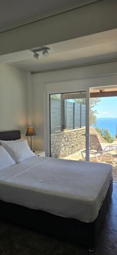 a bedroom with a bed and a view of the ocean at Apollo Romantic Sea View Villa in Kiveri