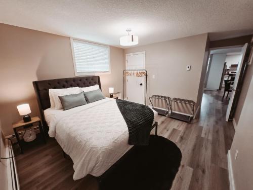 a bedroom with a large bed and a hallway at Riverfront Condo - Free Parking, Walk DT, Sleep 4 in Calgary