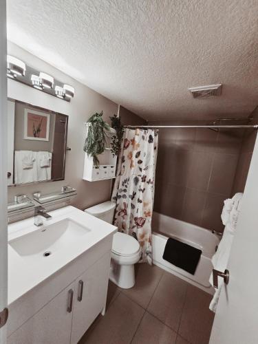 a bathroom with a sink and a toilet and a shower at Riverfront Condo - Free Parking, Walk DT, Sleep 4 in Calgary