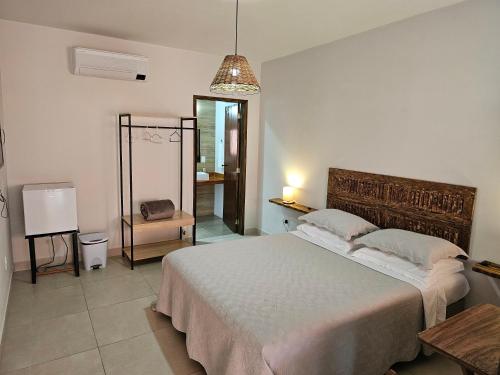 a bedroom with a large bed and a mirror at Pousada do Alferes in Paty do Alferes