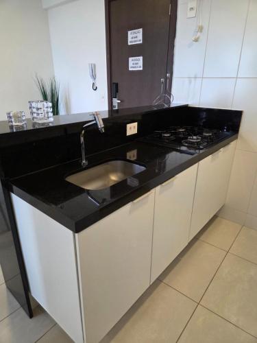 a bathroom counter with a sink and a stove at Apartamento Fantástico - com estação para carros eletricos in Campina Grande