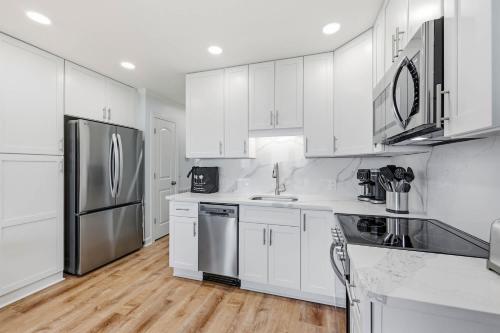 a kitchen with white cabinets and stainless steel appliances at Tide Time Oceanfront at Sea Cabin w Pool in Myrtle Beach