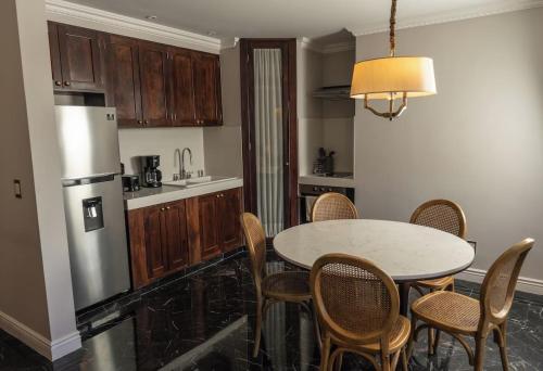 eine Küche mit Tisch, Stühlen und Kühlschrank in der Unterkunft Hotel Plaza 79 in San Cristóbal de las Casas