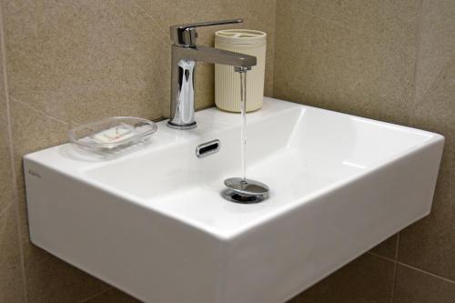 a white sink with a faucet on top of it at DOMUS Canonico in Noto