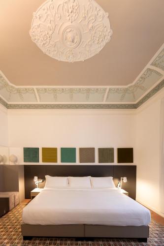 a bedroom with a large bed and a chandelier at Riflessi Acireale Palace Suites in Acireale