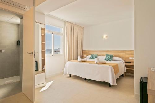 a hotel room with a bed and a window at Suncoast Ibiza Hotel - Adults Only - in Ibiza Town