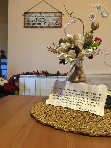 a vase of flowers on a table with a note at B&B Terrazza dell'Etna in Mascalucia