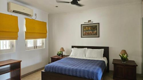 a bedroom with a bed with a blue comforter at Nora Lyn - Colombo in Colombo