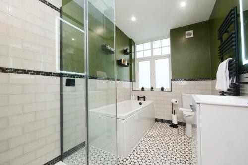 a bathroom with a tub and a sink and a toilet at The Wheatley in Denton