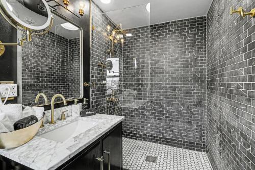 a black and white bathroom with a sink and a shower at Lil' Red House On Porter in Detroit