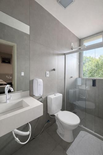a bathroom with a toilet and a sink and a shower at Vértice Hotel in Brasília