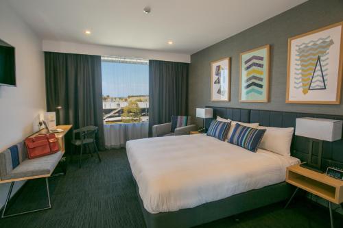 a hotel room with a large bed and a window at Alpha Hotel Eastern Creek in Blacktown