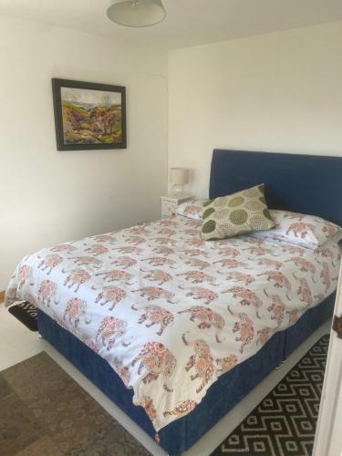 a bedroom with a bed with a quilt on it at THE Old DAIRY in Whitland