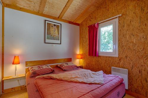 a bedroom with a bed and a window at Chalet D'alpion Nord avec Piscine in Les Tourrettes