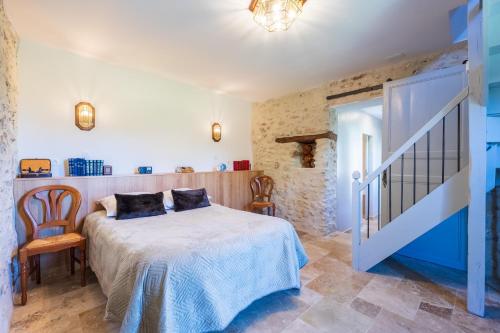 a bedroom with a bed and a staircase in a room at La Maisonnette de Marguerite - Avec Climatisation in Vendières