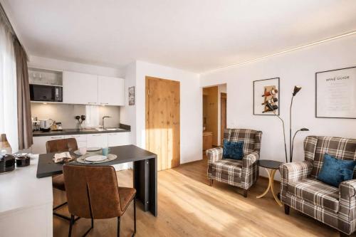 a kitchen and living room with a table and chairs at Aparthotel Viktorias Home in Kufstein