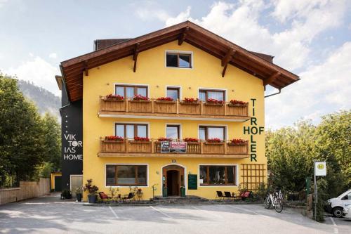 a yellow building with a wooden roof at Aparthotel Viktorias Home in Kufstein