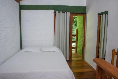 a bedroom with a bed in a room with a window at Chale 1 com Churrasqueira e Ar a 200m da Praia in Prado