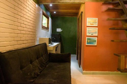 a living room with a couch and a brick wall at Chale 1 com Churrasqueira e Ar a 200m da Praia in Prado