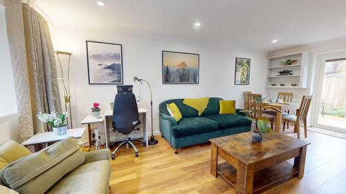 a living room with a couch and a table at Cherry Tree Cottage in Bicester
