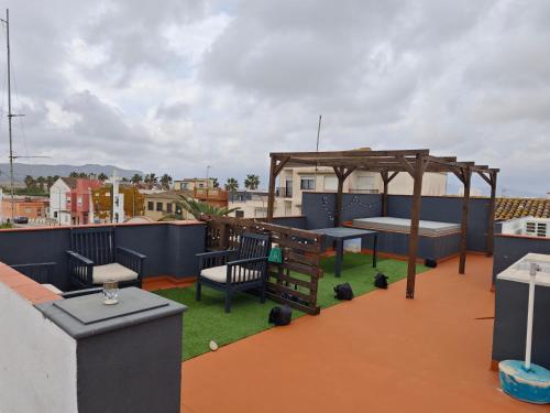 eine Dachterrasse mit einem Pavillon auf dem Dach in der Unterkunft SeaSuites Blue-Ático con terraza chillout cerca del mar en Cullera in Mareny de San Lorenzo
