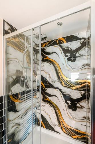 a glass cabinet with a painting of mountains at 4BD Spacious detached House in Birmingham suitable for Contractors and family's with free parking on private drive sleeps 9 in Birmingham