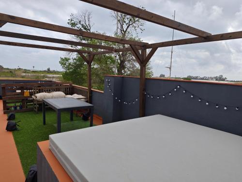 eine Dachterrasse mit einem Tisch und einem Picknicktisch in der Unterkunft SeaSuites Blue-Ático con terraza chillout cerca del mar en Cullera in Mareny de San Lorenzo