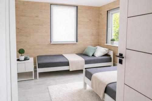 a small room with two beds and a window at Całoroczny Domek Chill in Sława