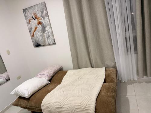 a bed in a room with a picture on the wall at Alojamiento Rozo in Girón