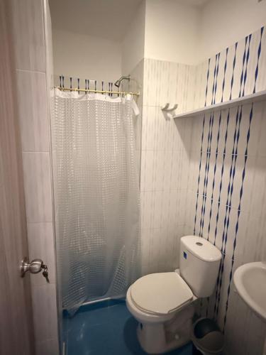 a bathroom with a toilet and a shower and a sink at Alojamiento Rozo in Girón