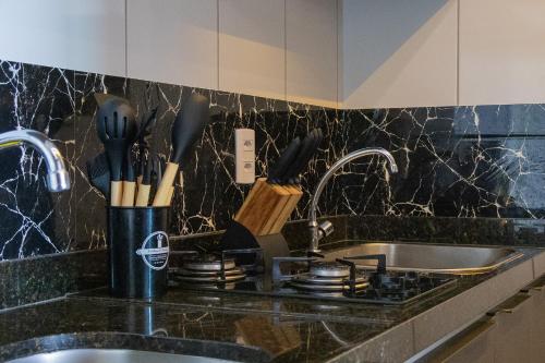 a kitchen counter with a sink and utensils at Aurora Fortaleza in Fortaleza