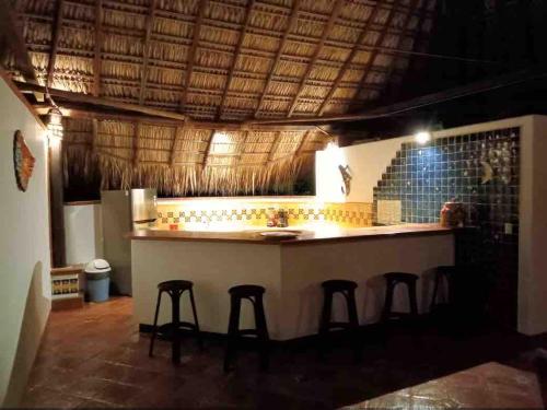 a kitchen with a bar with stools in a room at Penthouse Bella Vista in Puerto Escondido