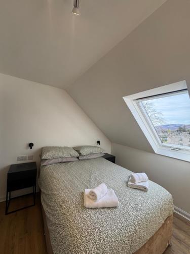 a bedroom with a bed with two towels on it at 2A Lochy Crescent in Inverlochy