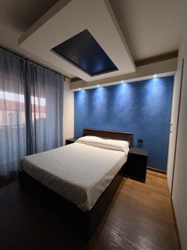a bedroom with a bed and a blue wall at La casa nel parco in Chieri
