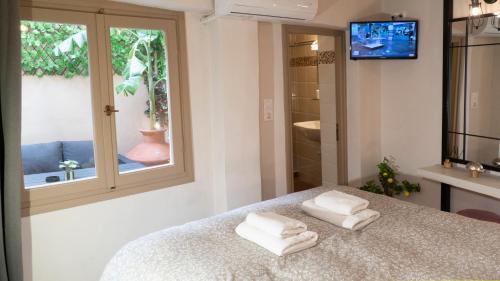 a bedroom with two towels on a bed with a window at ISIDORA home in Rethymno