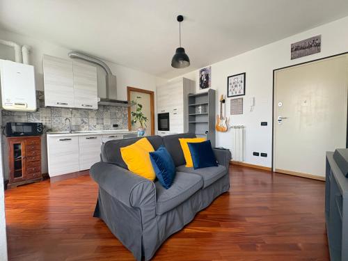a living room with a gray couch with blue and yellow pillows at La Casa sul Serio in Seriate