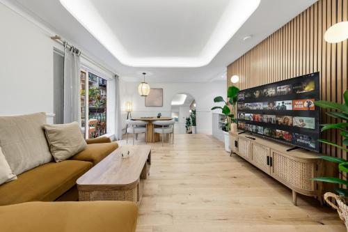 a living room with a couch and a tv at Tranquil 2B Japandi-Inspired Apt 2 min from St Paul's in London