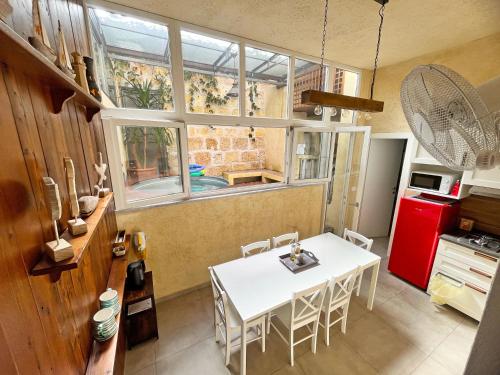 a kitchen with a white table and a red refrigerator at Basso 61 Urban Oasis with Private Mini Pool & Courtyard - Families & Groups in Palermo