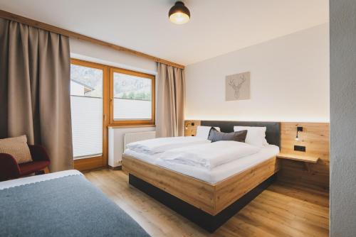 a bedroom with a large white bed and a window at Apartpension Oberhauser in Kaprun