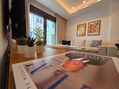 a living room with a table with a poster on it at New! Marbella Apartamento junto a la Playa y Casco Histórico - 2 Habitaciones Dobles - 80 m2 in Marbella