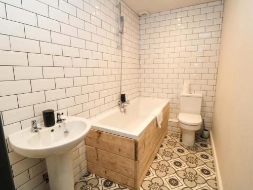 a bathroom with a tub and a sink and a toilet at Craven Suite in Scarborough
