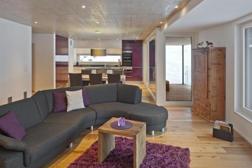 a living room with a couch and a table at Sera Lodge in Grächen