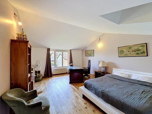 a bedroom with a bed and a chair and a desk at La Parenthese in Blyes