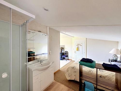 a bedroom with a bed and a sink and a mirror at La Parenthese in Blyes