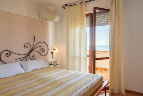 a bedroom with a bed with a view of the ocean at Appartamenti La Vecchia Posta - 50 mt dal Mare in Marina di Grosseto